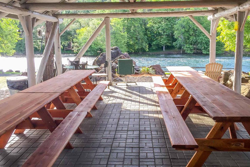 redwood picnic tables under canopy at campground