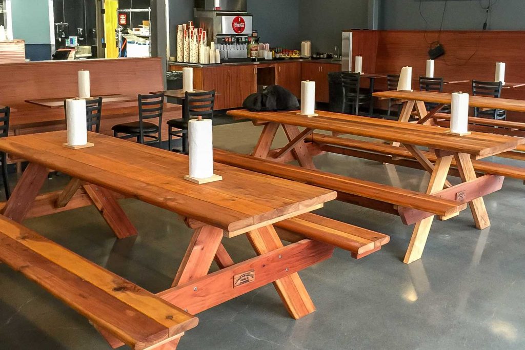 redwood picnic tables indoors in eatery